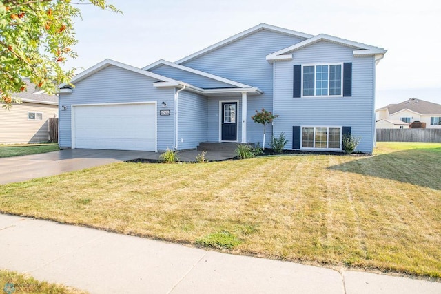 tri-level home featuring a garage and a front lawn