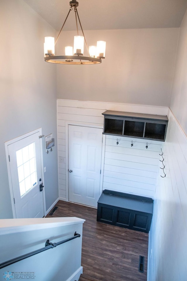 mudroom with an inviting chandelier and dark hardwood / wood-style flooring