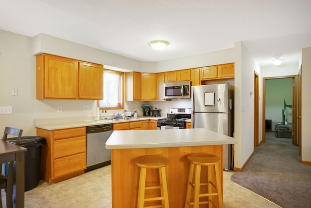 kitchen featuring a breakfast bar area, appliances with stainless steel finishes, and a center island