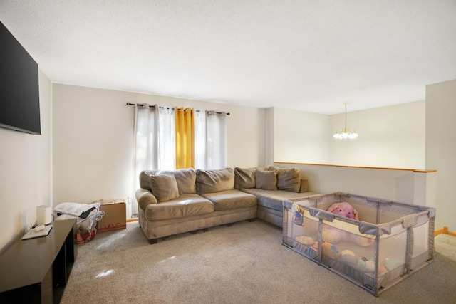 living room with a textured ceiling, carpet flooring, and an inviting chandelier