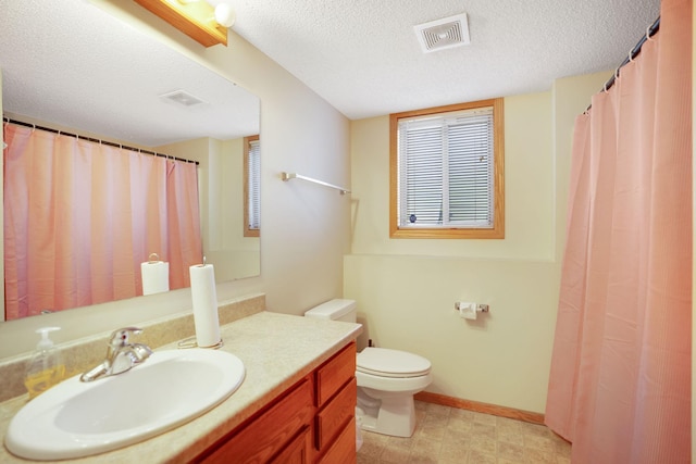 bathroom featuring a textured ceiling, vanity, and toilet