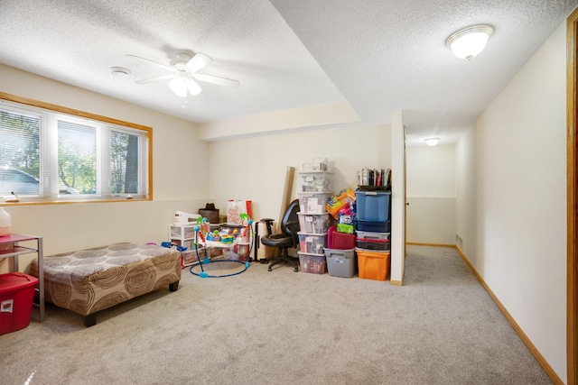 game room with carpet, ceiling fan, and a textured ceiling