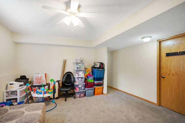 playroom featuring carpet floors, a textured ceiling, and ceiling fan