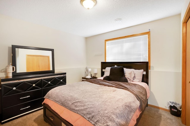 bedroom featuring a textured ceiling and dark carpet