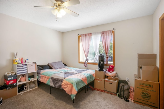 bedroom with ceiling fan, carpet flooring, and a textured ceiling