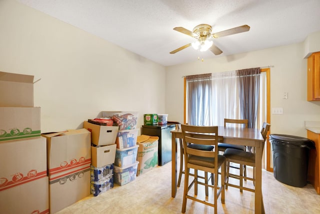 dining space featuring ceiling fan and a textured ceiling