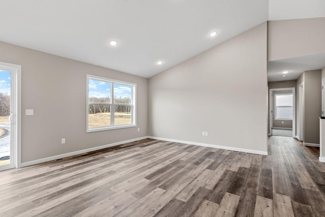 empty room featuring light hardwood / wood-style floors and vaulted ceiling