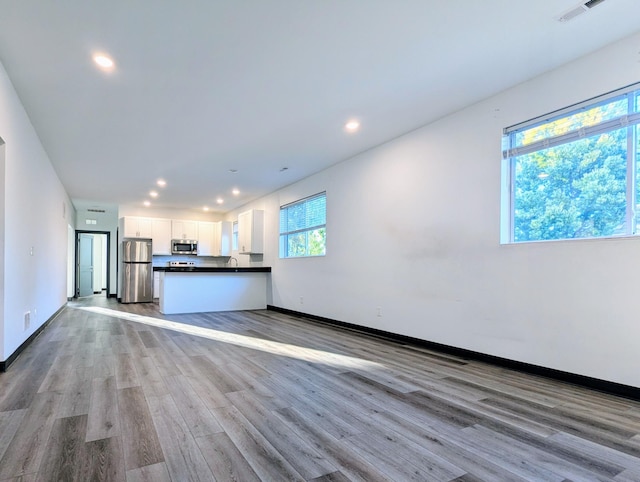 unfurnished living room featuring light hardwood / wood-style flooring and sink