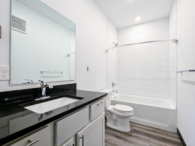 full bathroom featuring tiled shower / bath, vanity, toilet, and wood-type flooring