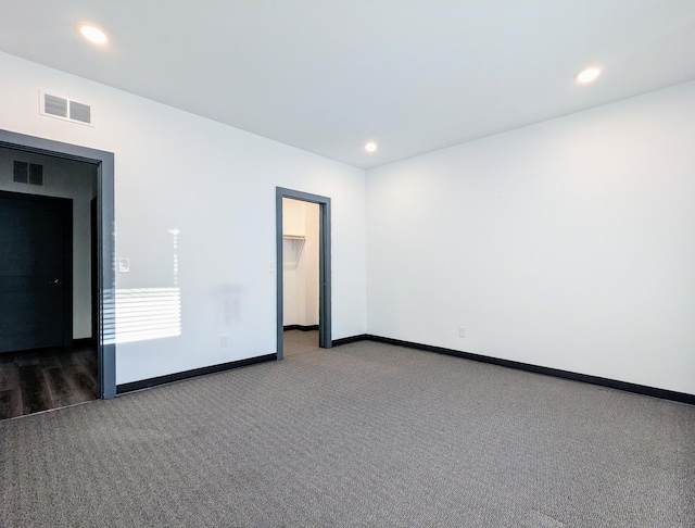 empty room with dark colored carpet