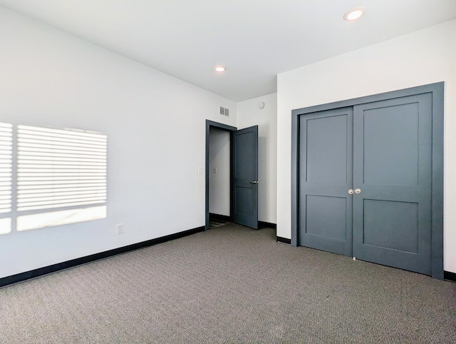 unfurnished bedroom featuring a closet and light colored carpet