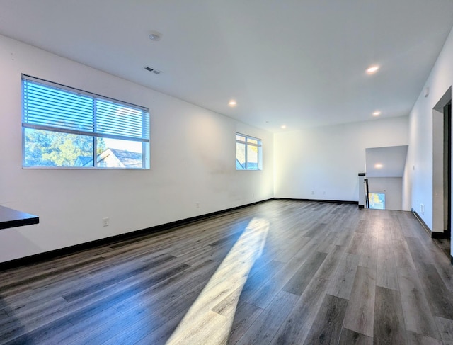 spare room with dark wood-type flooring and a wealth of natural light