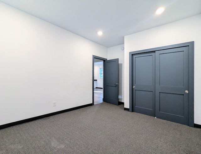 unfurnished bedroom featuring carpet floors and a closet