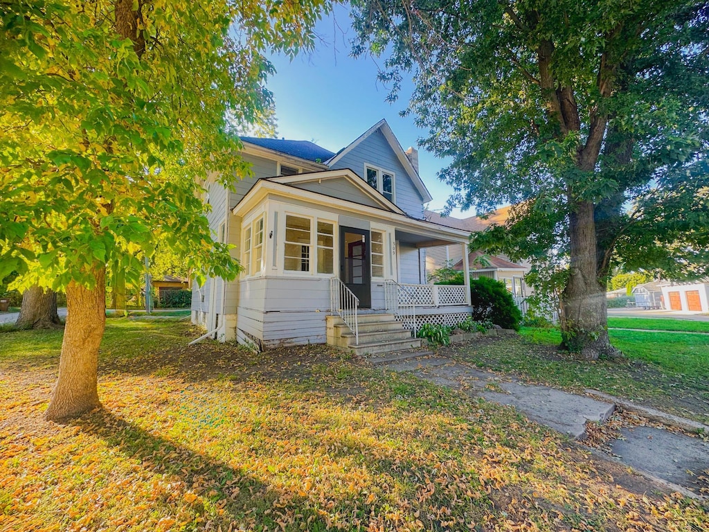 view of front of home with a porch and a front lawn