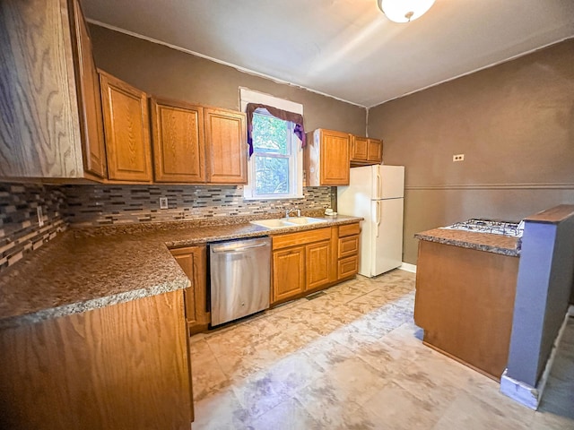 kitchen featuring backsplash, stainless steel dishwasher, sink, and white fridge