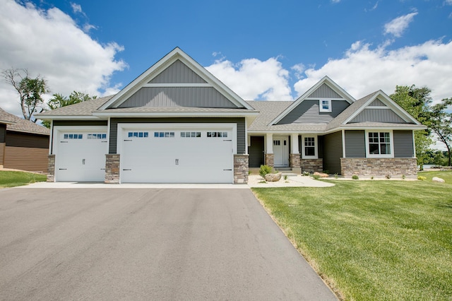 craftsman-style house with stone siding, aphalt driveway, a garage, and a front yard