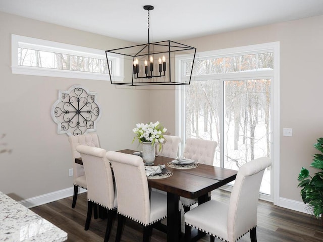 dining space featuring baseboards, dark wood-style flooring, and an inviting chandelier