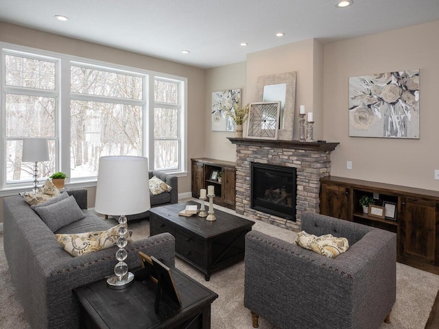 living room featuring recessed lighting and a stone fireplace