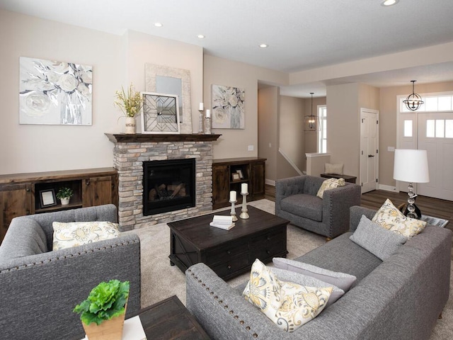 living room featuring baseboards, wood finished floors, a glass covered fireplace, and recessed lighting