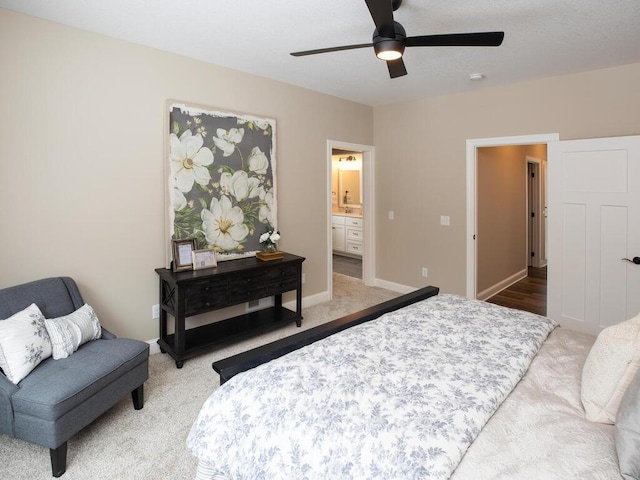 bedroom with connected bathroom, baseboards, ceiling fan, and carpet floors