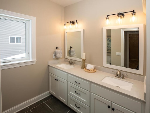 full bathroom with tile patterned flooring, a sink, double vanity, and baseboards