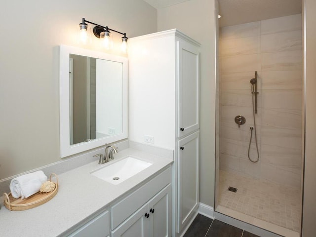 bathroom featuring tiled shower, vanity, and tile patterned flooring