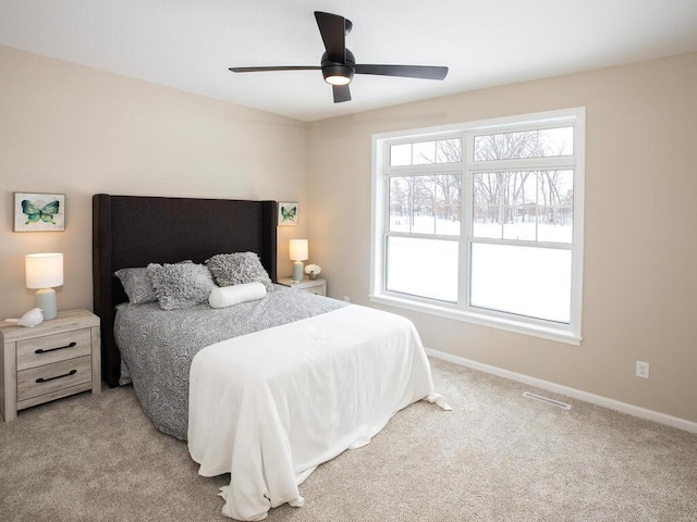 carpeted bedroom with baseboards, visible vents, and ceiling fan