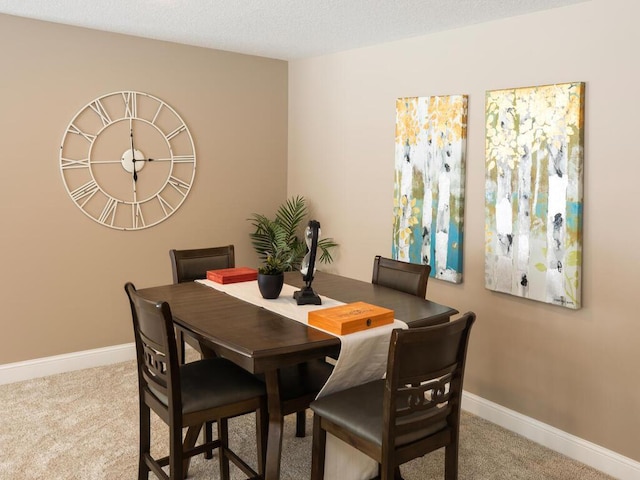 dining room featuring light colored carpet and a textured ceiling