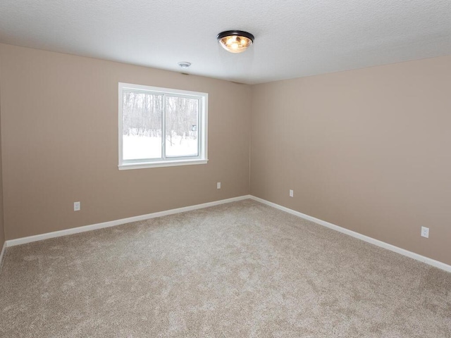 carpeted empty room with a textured ceiling