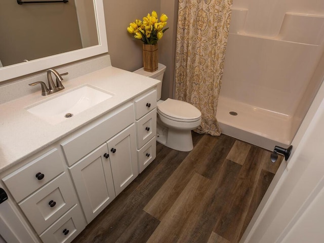 bathroom with walk in shower, toilet, vanity, and hardwood / wood-style floors