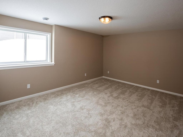 carpeted empty room with a textured ceiling