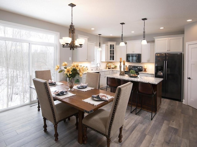 dining space with dark wood-style flooring, an inviting chandelier, and recessed lighting