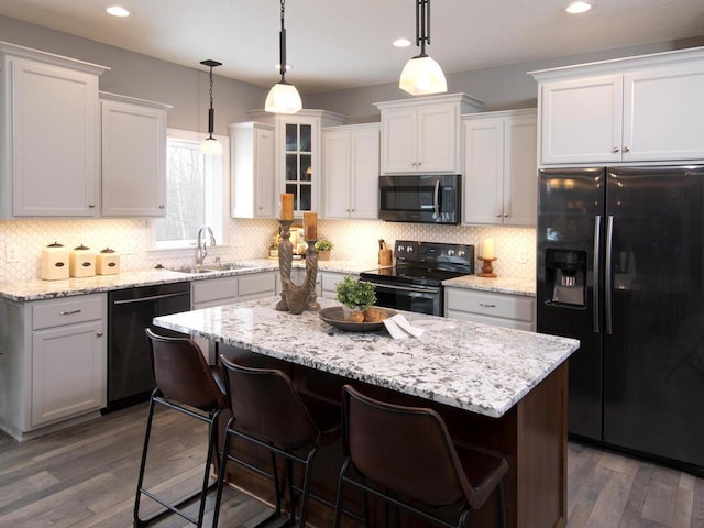 kitchen with white cabinets, dark hardwood / wood-style floors, and black appliances