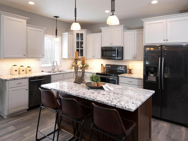 kitchen with dark wood-style flooring, stainless steel microwave, electric range oven, dishwashing machine, and black refrigerator with ice dispenser