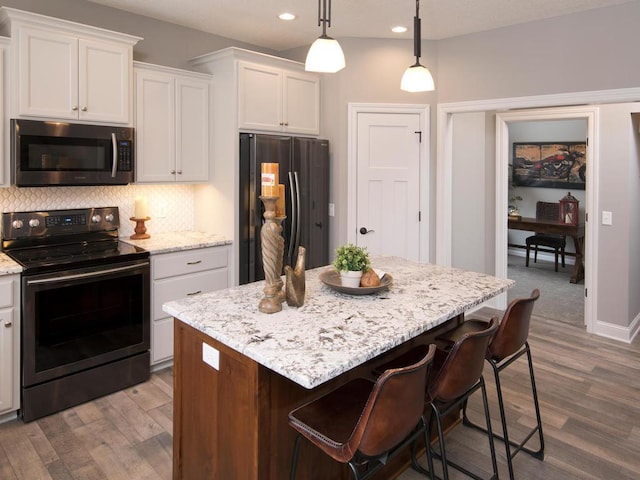 kitchen featuring white cabinetry, decorative backsplash, appliances with stainless steel finishes, and dark wood-style flooring