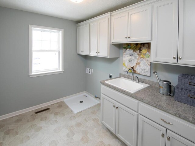 clothes washing area with washer hookup, hookup for an electric dryer, cabinets, sink, and gas dryer hookup