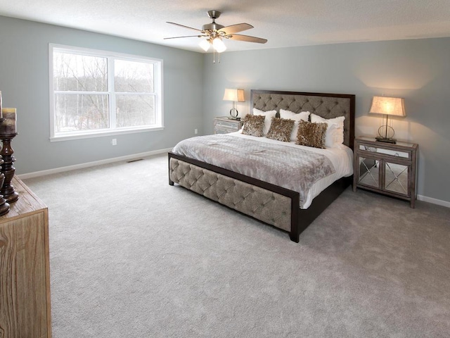 carpeted bedroom featuring baseboards, a textured ceiling, ceiling fan, and visible vents
