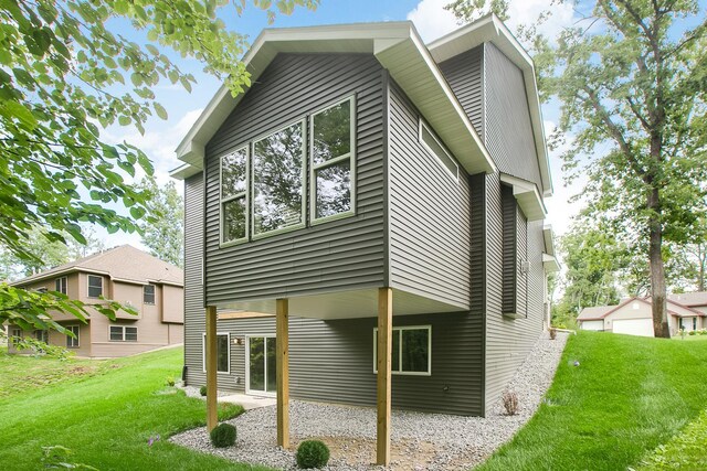 back of property with a garage and a lawn