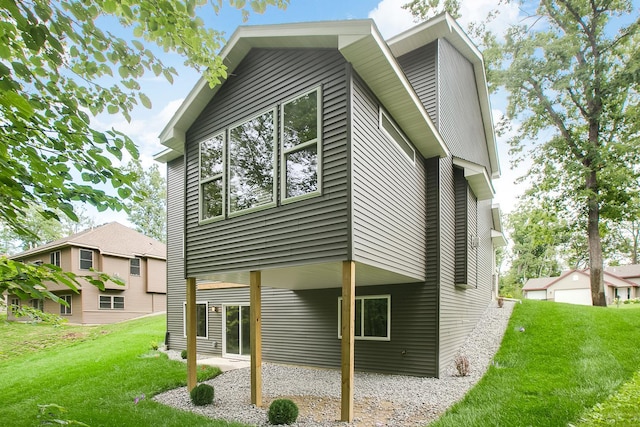back of house with a patio area and a yard