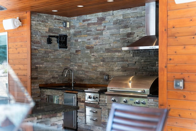 interior space with wall chimney exhaust hood, wooden ceiling, stainless steel refrigerator, and sink