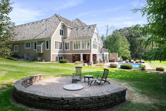 back of house with a yard, central AC, a patio, and a fire pit