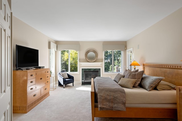 carpeted bedroom with a premium fireplace