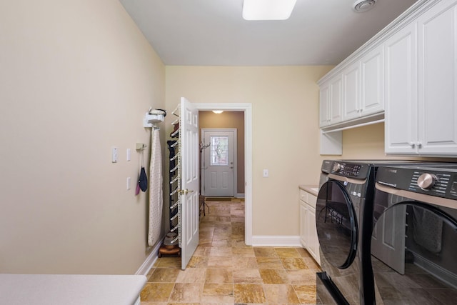 laundry room featuring washing machine and clothes dryer and cabinets