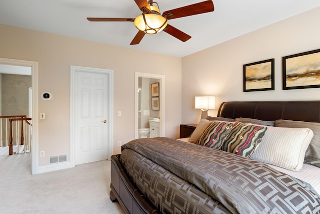 bedroom featuring ceiling fan, light carpet, and ensuite bathroom