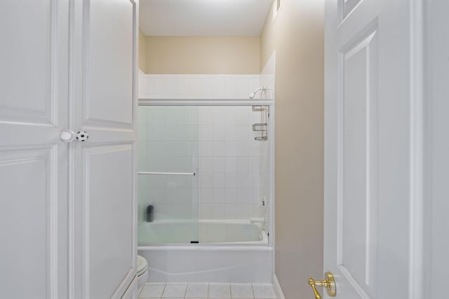 bathroom with tile patterned flooring, toilet, and enclosed tub / shower combo