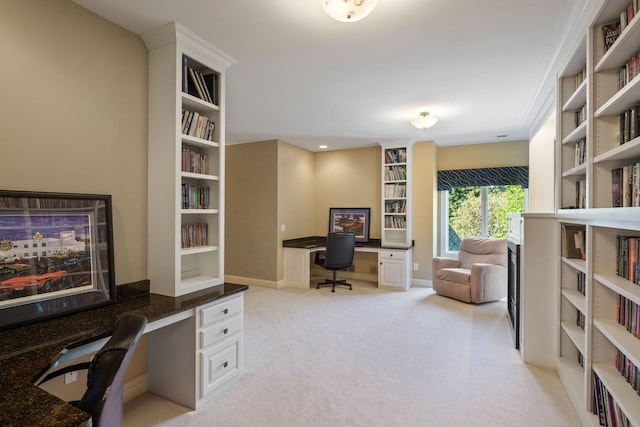 carpeted office space featuring built in desk