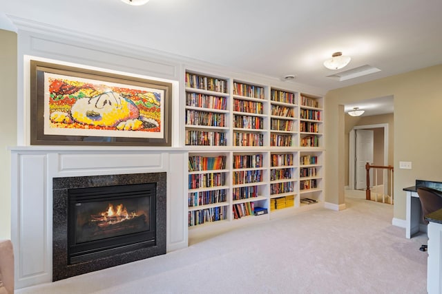 living area featuring a fireplace, built in features, and light colored carpet