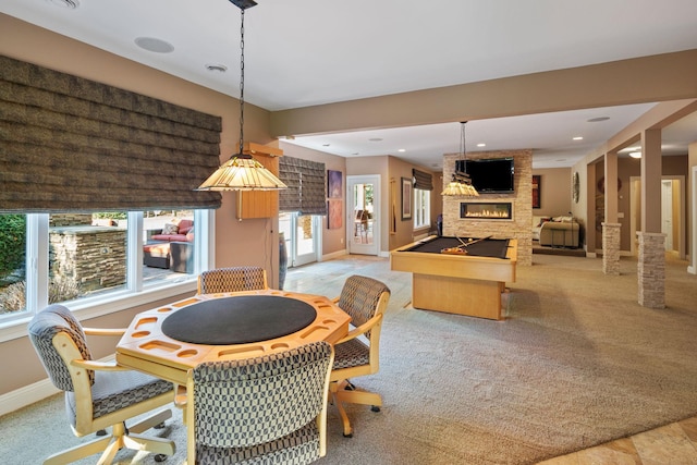 carpeted dining space featuring a stone fireplace and billiards