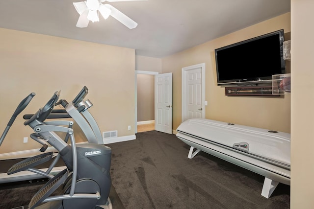 workout room featuring ceiling fan and dark colored carpet