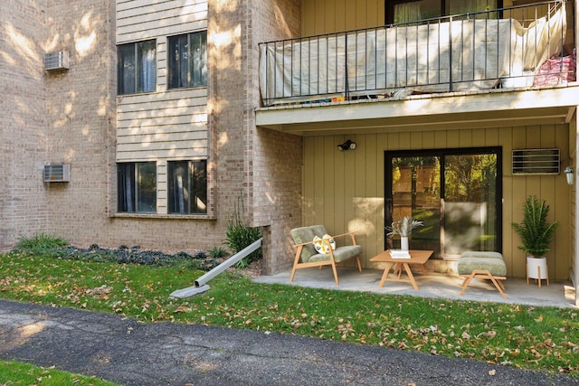 property entrance with a patio area and a balcony